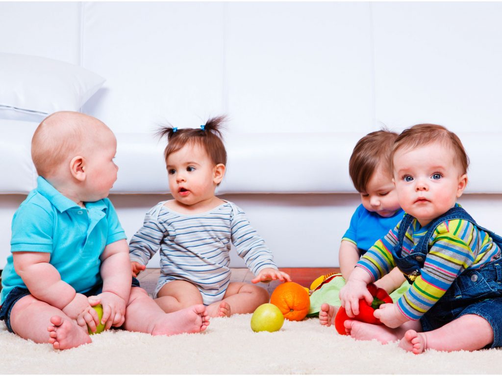 Bebés jugando en la alfombra con frutas - La Tienda Home